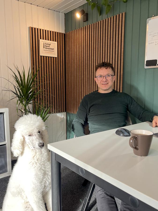 Max Stebner mit seinem Hund im Büro